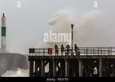 Wales, UK. 5. Dezember 2015-Gruppe von Fußgängern Stand in der Nähe von den riesigen Wellen, die die konkreten Anlegestelle Misshandlung sind, wie Storm Desmond Aberystwyth orkanartigen Winden und rauer See bringt. Bildnachweis: Ian Jones/Alamy Live-Nachrichten Stockfoto