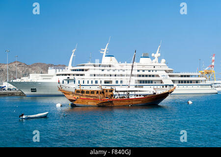 Holzboot vertäut neben der super-Yacht des Sultans von Oman im Hafen von Mutrah, Muscat. Stockfoto