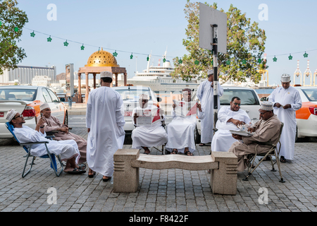 Omanische Taxifahrer lesen Zeitungen an der Promenade von Mutrah in Muscat, der Hauptstadt des Sultanats Oman. Stockfoto