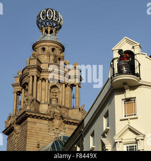 Eine Figur mit einem Bierfass auf dem Dach des Chandos-Pub, neben der Welt des West End von London Coliseum Theatre in London Stockfoto