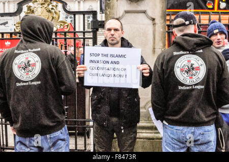 Belfast, Nordirland. 5. Dezember 2015 - ein Mann hält ein Plakat mit der Meldung "Stop der islamischen Invasion und Besiedlung unseres Landes jetzt!" während die beiden Männer tragen Hoodies mit dem Slogan "Northern Ireland Defence League.  Kein Verzicht auf den Islam ". Bildnachweis: Stephen Barnes/Alamy Live-Nachrichten Stockfoto