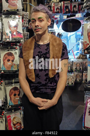 Porträt eines jungen Mannes mit lila Haaren, grünen Augenbrauen und einen grauen Schnurrbart auf dem Halloween Adventure Shop in New York City Stockfoto