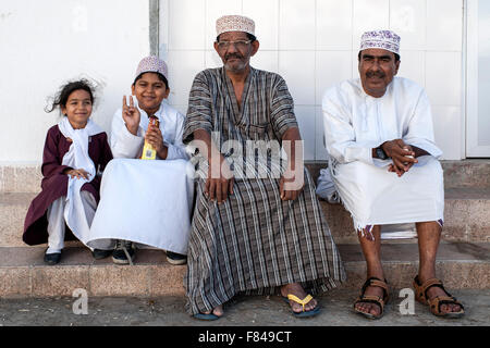 Omanische Männer und Kinder sitzen in alten Muscat, der Hauptstadt des Sultanats Oman. Stockfoto