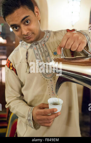 Ein Kellner gießt Kaffee im Bait Al Luban Restaurant in Muscat, der Hauptstadt des Sultanats Oman. Stockfoto