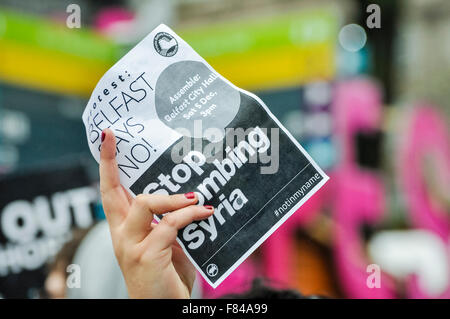 Belfast, Nordirland. 5. Dezember 2015 - eine Frau hält einen Plakat-Flyer für einen Rallye-Spruch "Belfast sagt Nein! Bombardierung von Syrien zu stoppen "Credit: Stephen Barnes/Alamy Live News Stockfoto