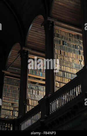 Antike Bücher in den Regalen in der Long Room der alten Bibliothek des Trinity College in Dublin, Irland Stockfoto