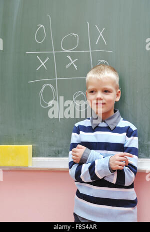 glückliche junge am ersten Klasse Mathe Klassen lösen von Problemen und Lösungen finden Stockfoto