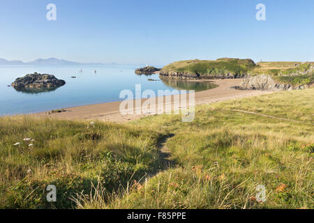 Strand auf der Insel Llanddwyn, Anglesey mit dem Lighhouse im Hintergrund und die Llyn Halbinsel in der Ferne Stockfoto