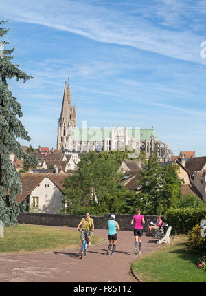Frau Rad und weibliche Jogger mit Kathedrale im Hintergrund Chartres, Eure-et-Loir, Frankreich, Europa Stockfoto