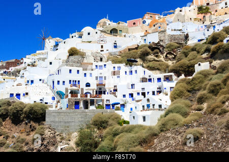 Kykladen, Santorini, Thira. Oia. Weiße und blaue Feriensiedlung Felswand mit Stadt hinter eingebaut. Stockfoto