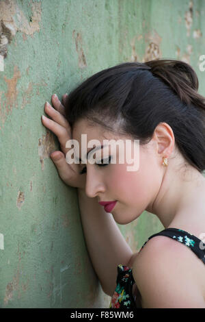 Traurige junge Frau, die an die Wand gelehnt Stockfoto
