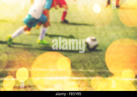 Verschwommene Kinder spielen Fußball, jungen für den Ball laufen, getönten Retro Bild mit leichten bokeh Stockfoto