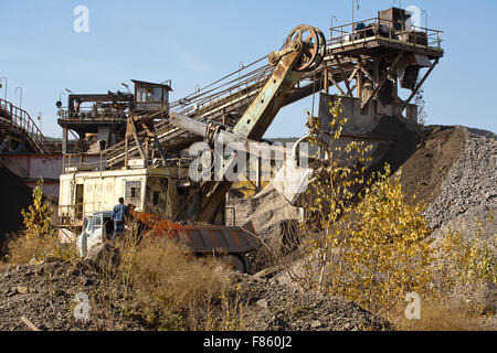 Bagger gießt Schutt in einem LKW Stockfoto