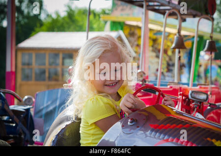 Kind gilt für eine Fahrt auf einem Kinder-Attraktion Stockfoto