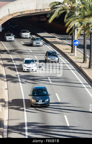 Autos kommen aus einem Tunnel einer raschen städtischen Straße Stockfoto