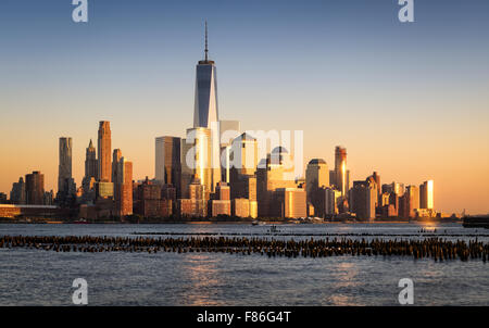 Lower Manhattan Financial District Wolkenkratzer bei Sonnenuntergang über Hudson River mit World Trade Center. New York City Stockfoto