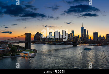 Erhöhten Blick auf die Brooklyn Bridge, East River, Lower Manhattan, Wolkenkratzer und Wolken bei Sonnenuntergang. New York City Stockfoto