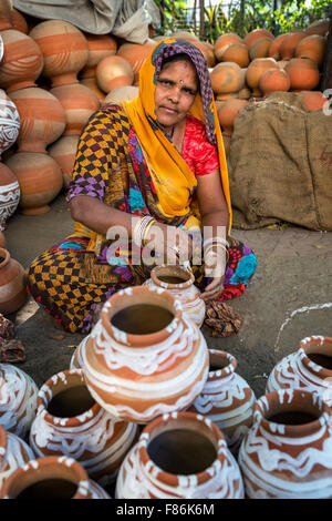 Eine Frau Malerei Töpfe und Krüge Wasser in einer Töpferei stall in Jaipur, Rajasthan, Indien Stockfoto