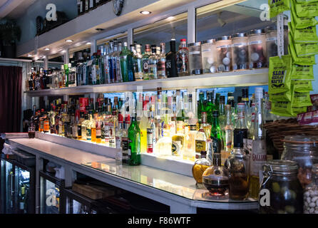 Barinnenseite – Spirituosenflaschen auf einem Regal hinter der Bar Stockfoto
