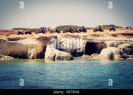 Meeresgrotten, Bezirk Paphos, Zypern - 24. Juli 2015: Touristen auf Quads Stockfoto