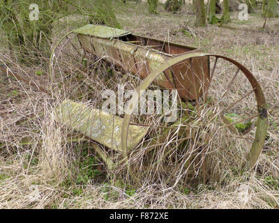 Links ein Stück der alten Landmaschinen zu lange Gras auf einer Farm in Nottinghamshire alte Samen Bohrer aus Gusseisen Räder Landschaft verrotten Stockfoto