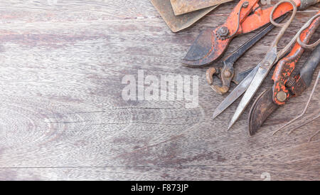 Alte rostige Werkzeuge - Vintage Handarbeit auf hölzernen Hintergrund mit Textfreiraum Stockfoto