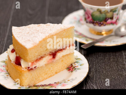 Ein Stück vom Victoria Schwammkuchen und eine Tasse Kaffee mit antiken reich verzierten Geschirr - Studio mit einer geringen Schärfentiefe erschossen Stockfoto