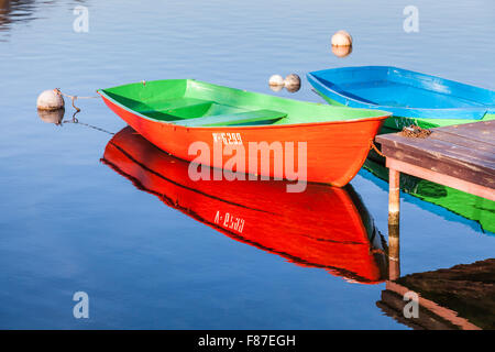 Bunten Ruderboote vertäut am Seeufer und Reflexion, Lake Galve, Trakai, eine historische Stadt und Resort in Litauen mit Reflexionen Stockfoto