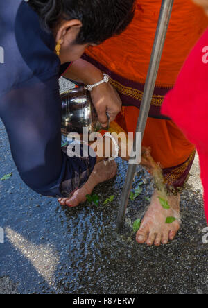 Frau, frisches Wasser auf die Füße ein Hindu ergebenen jährlichen Thaipusam religiöse Festival In Batu-Höhlen, Südost-Asien, Kuala Lumpur, Malaysia Stockfoto