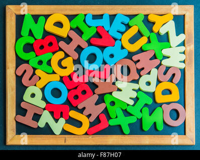 Mix-Alphabet bunte hölzerne Wort am schwarzen Brett Stockfoto