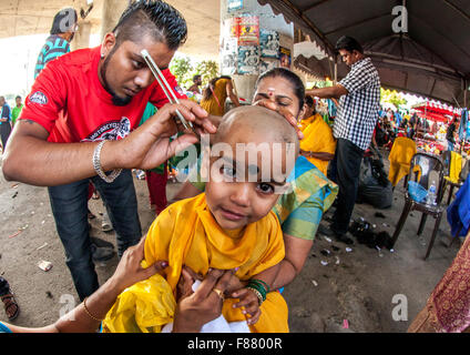 Kind wird rasiert mit einem Rasiermesser In jährlichen Thaipusam religiöse Festival In Batu-Höhlen, Südost-Asien, Kuala Lumpur, Malaysia Stockfoto