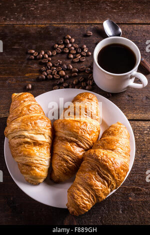 Kaffee und Croissants zum Frühstück am rustikalen Holztisch Stockfoto