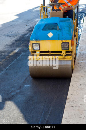 kleinen Tandem Vibration Walze Verdichter arbeitet an Asphaltdecke Stockfoto