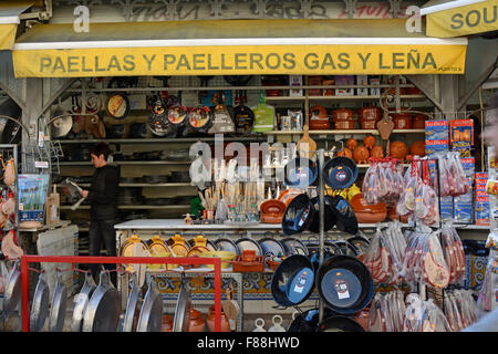 Hardware und Kochgeschirr Shop mit Outdoor-Display von Töpfen und Paella-Pfannen. In der Nähe von Indoor-Markt in Valencia, Spanien. Frau-Assistent Stockfoto