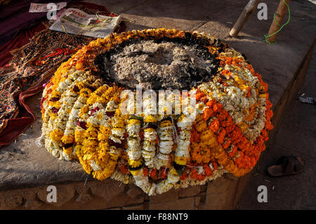 Devoteies und Sadhus Gebrauch schön gestaltete Kamin mit Ringelblume Girlanden am Ufer des heiligen Flusses Ganges in Varanasi. Stockfoto