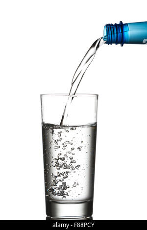 Wasser aus einer blauen Plastikflasche in ein Glas gießen.  Isoliert auf weißem Hintergrund Stockfoto