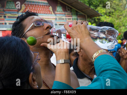 Frau, die er Wasser, ein Hindu Devotee jährlichen Thaipusam religiöse Festival In Batu-Höhlen, Südost-Asien, Kuala Lumpur, Malaysia Stockfoto
