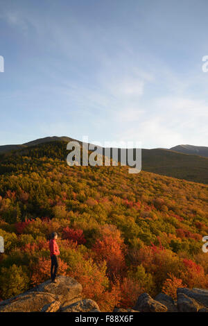 Wanderer, die Anzeige Peak Herbstfarben bei Sonnenuntergang auf North Zuckerhut, White Mountains New Hampshire Stockfoto