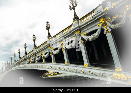 Kunstvolle Reliefs und Lampen auf der Brücke Alexandre III in Paris, Frankreich Stockfoto