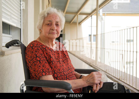 Porträt der Seniorin im Rollstuhl, auf der Terrasse eines Altenheims. Stockfoto