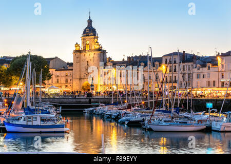 La Rochelle, Frankreich 9. August 2015: Tour De La Grosse Horloge im alten Hafen bei Sonnenuntergang, Charente Maritime Stockfoto