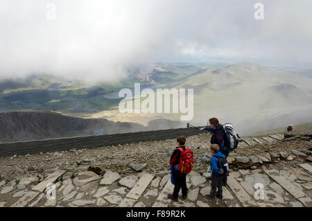 Frau zeigt sich der Blick auf ihre beiden Kinder bei der Bergstation der Snowdon Mountain Railway in Nord-Wales. Stockfoto