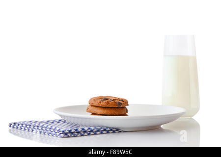 Stapel von drei hausgemachten Schokoladenkekse auf weißen Keramikplatte auf blaue Serviette und ein Glas Milch, isoliert auf weiss Stockfoto