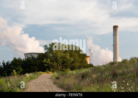 Ein großes Kohle befeuerten Kraftwerk hinter einem Hügel mit einem Feldweg in Richtung zu ihm führt. Stockfoto