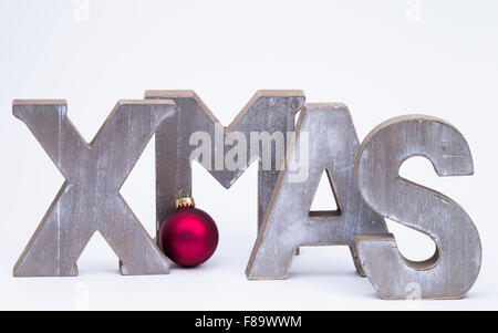 Großbuchstaben bilden das Wort x-mas mit rote Weihnachtskugel in weiß Stockfoto