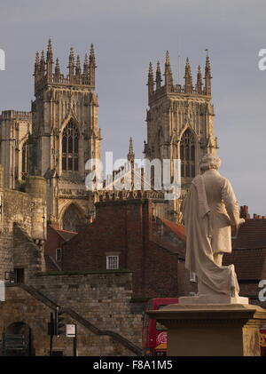 Das York Minster vom Exhibition Square aus über die Dächer mit der Statue des Künstlers William Etty im Vordergrund. Stockfoto