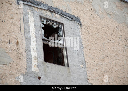 zerbrochenes Fenster auf Vandalismus Gebäude aus Stein Stockfoto