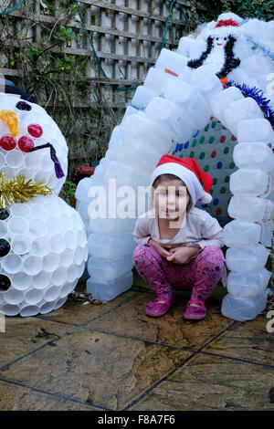 Weihnachtsschmuck Garten Iglu hergestellt aus Kunststoff Milchtüten mit Kind sitzen vor Stockfoto