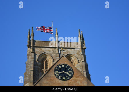 Der Union Jack fliegen auf Halbmast auf der Fahnenstange von Sherborne Abbey, Dorset, England Stockfoto