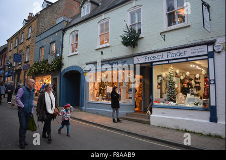 Familie wandern vorbei an Geschäften für Weihnachten in Cheap Straße eingerichtet. Weihnachts-shopping.  Sherborne, Dorset, Großbritannien Stockfoto